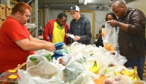 (Left to right) Jesse Lewis, James Watson, Kevin Roberts, Maria Poncy and Cimerion Watson, volunteers with EmployAbility, package NLaws at Home food items for St. Joseph's / Candler orders.
